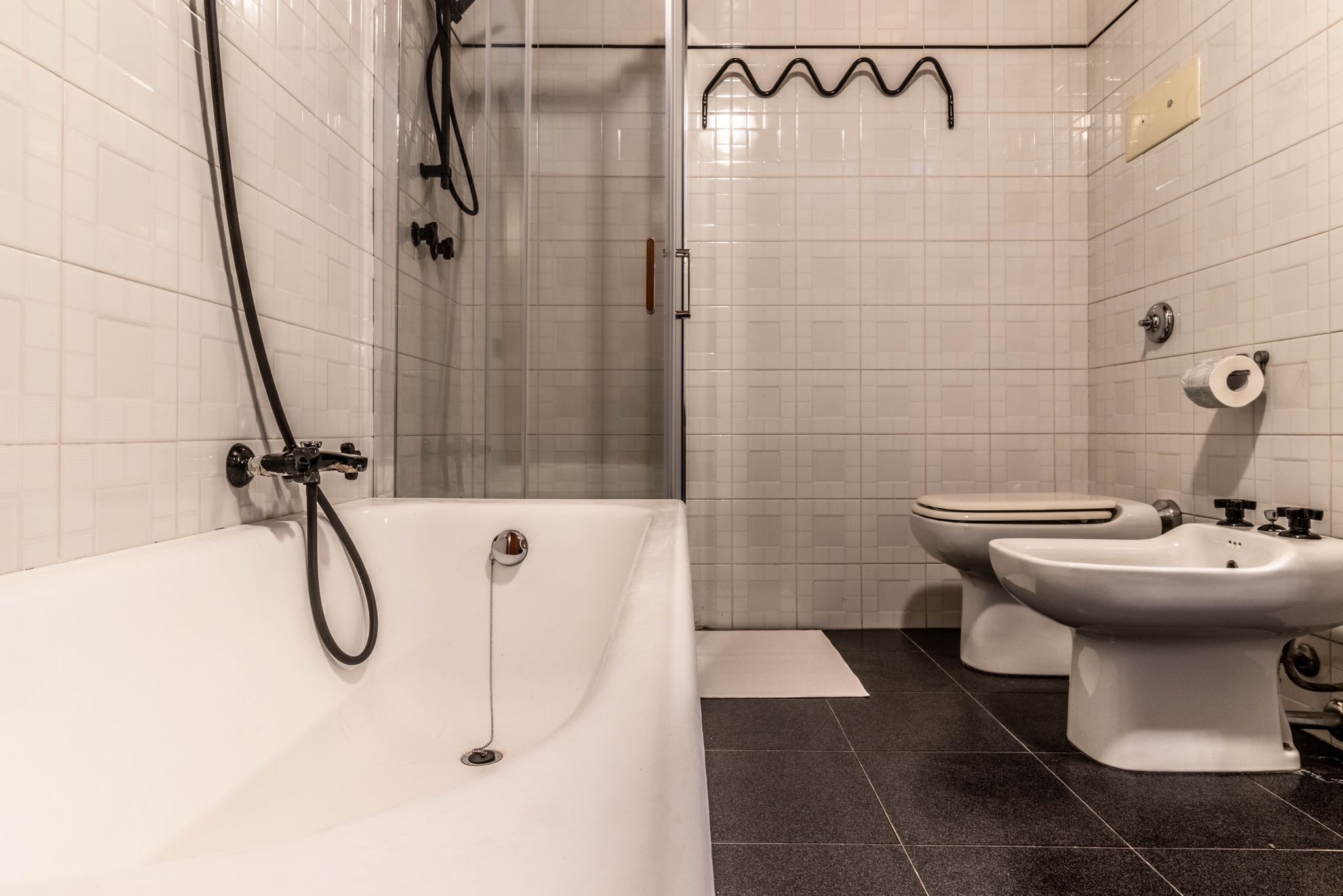 Bathroom with bathtub, shower enclosure, toilet, and bidet