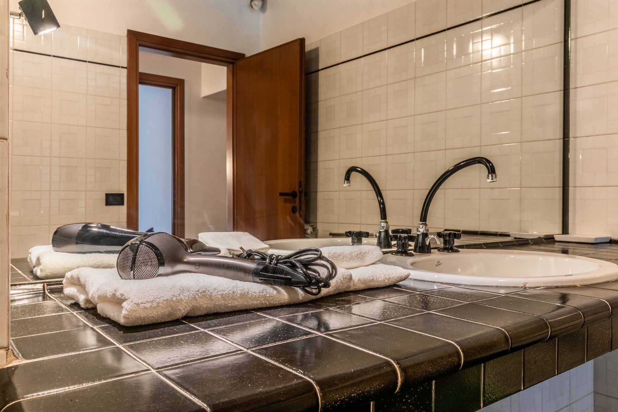 Bathroom vanity with sink, towels, and hairdryer