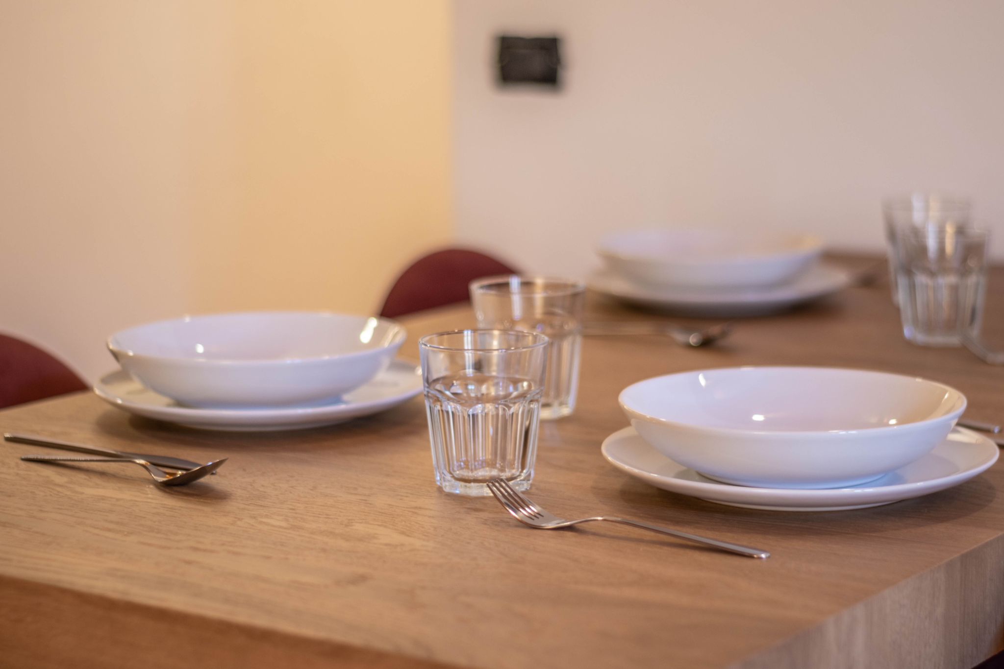 Dining table place setting with bowls, glasses, and cutlery