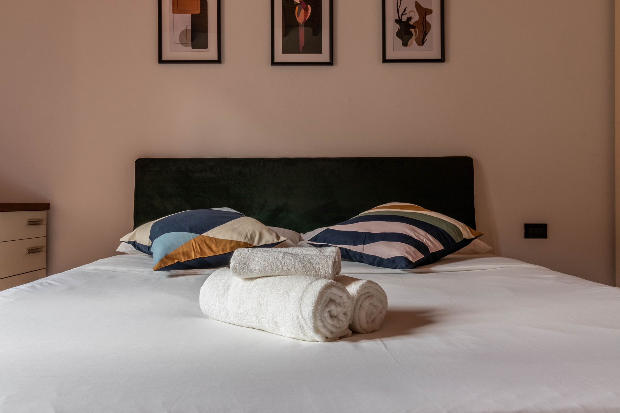 Front view of the guest bedroom bed with pillows and folded towels
