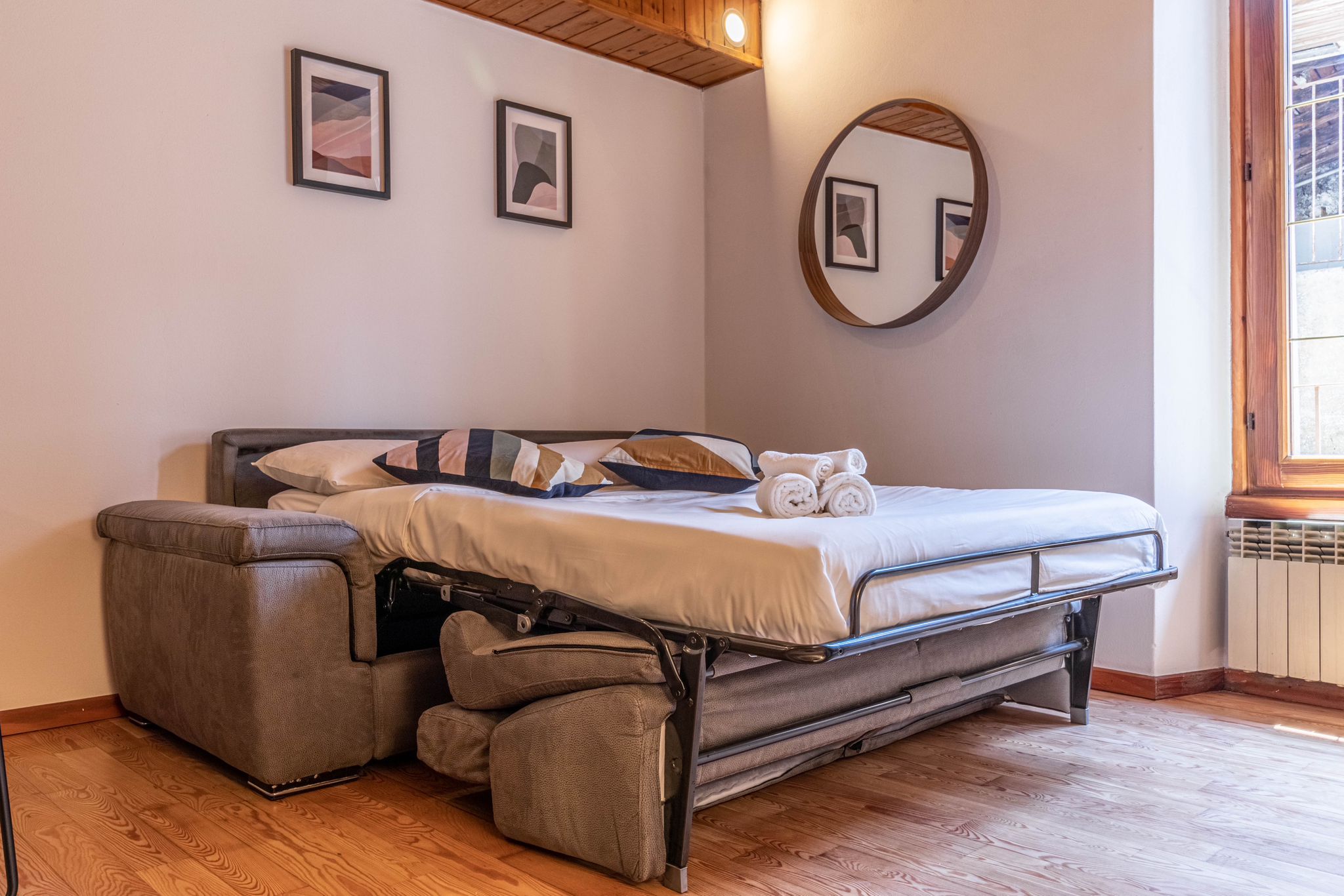 Sofa bed opened in the living area beside the window