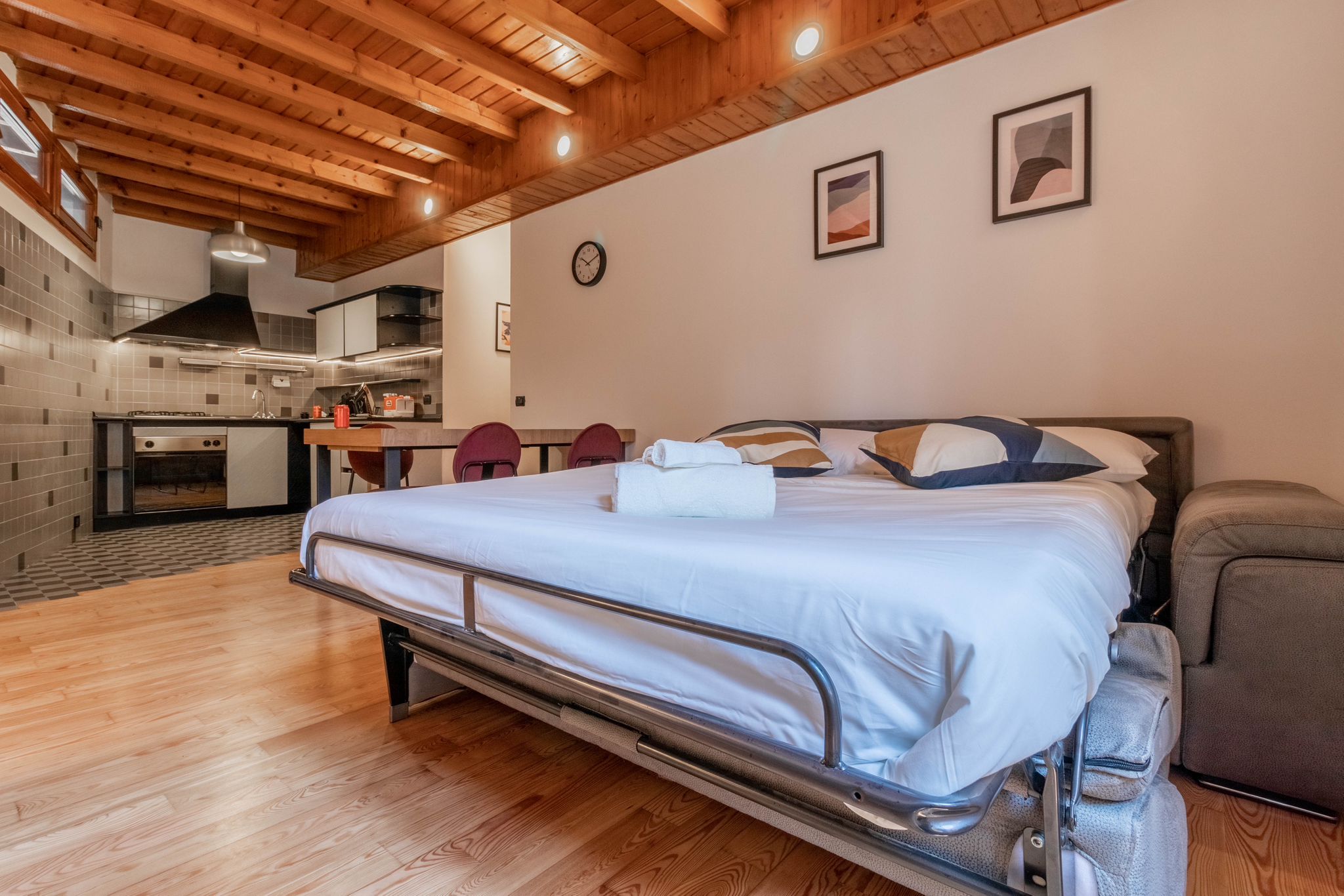 Open sofa bed in the living area with the kitchen in the background