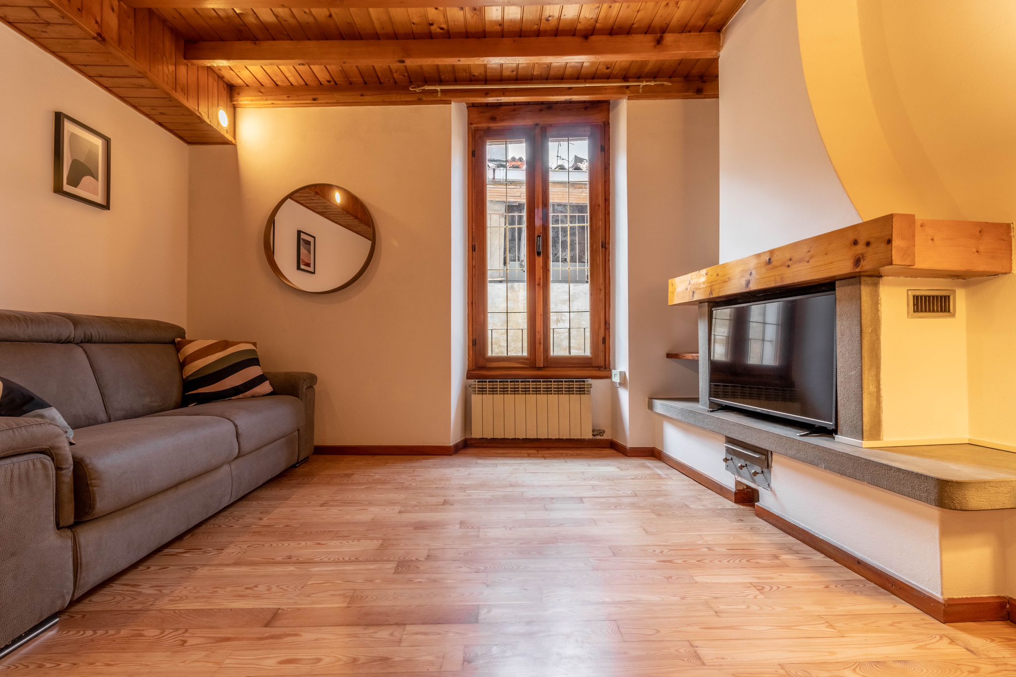 Living area with sofa, fireplace feature, and tall window