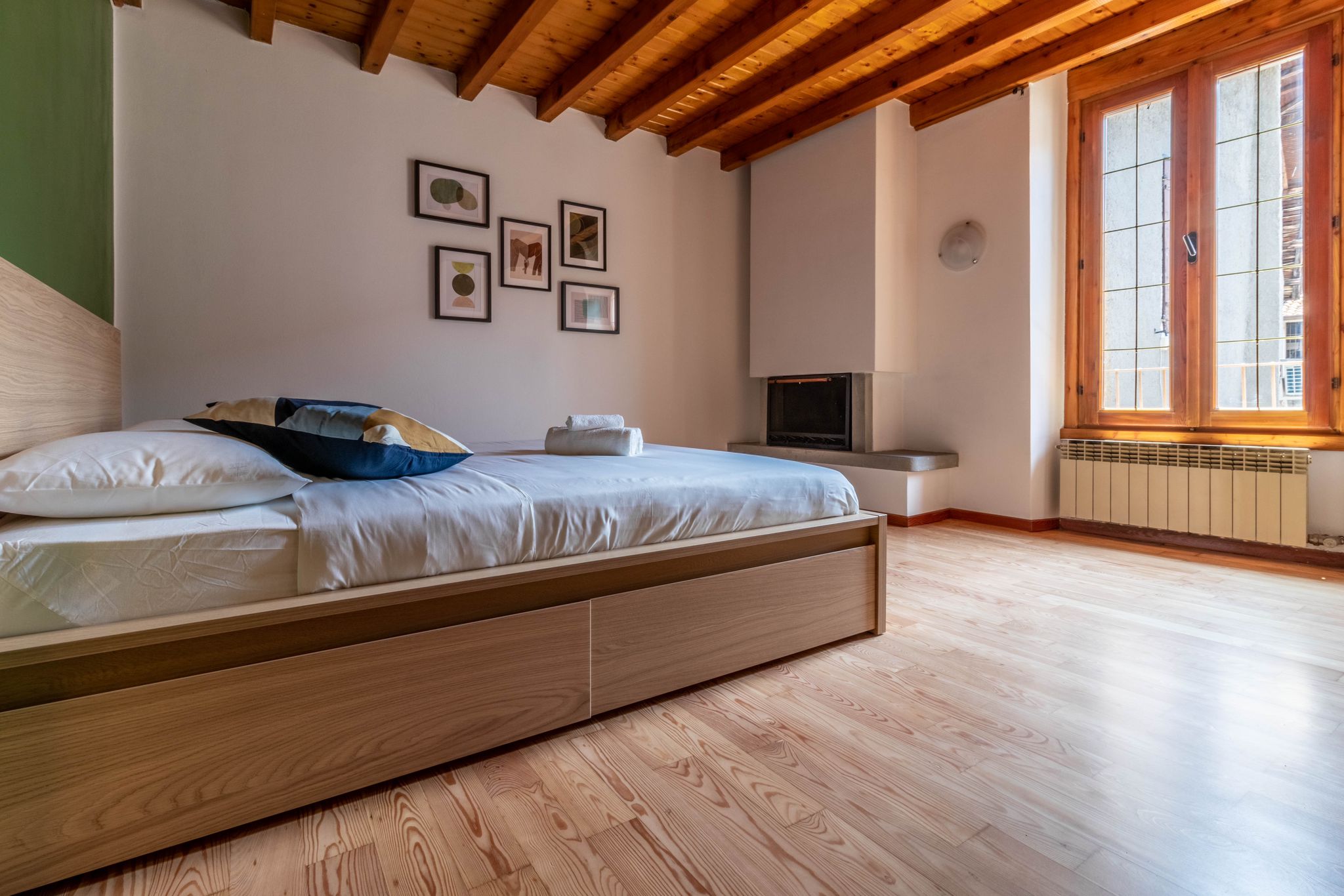 Primary bedroom with bed, decorative fireplace, and tall window